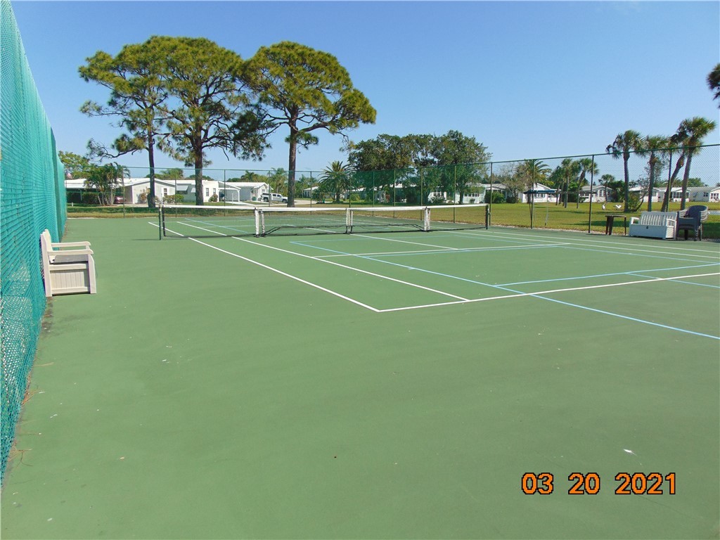 7615 Montauk Avenue, Unit R9 Micco, FL 32976 - Photo 36 of 36 a view of a tennis ground with large trees