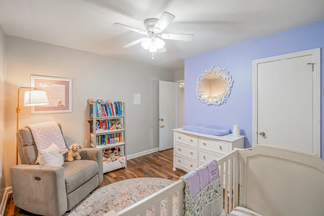 a living room with furniture and a baby crib