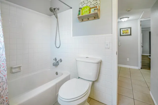 a white toilet sitting next to a bath tub and a shower