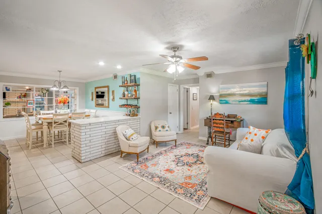 a living room with furniture and a dining table with kitchen view