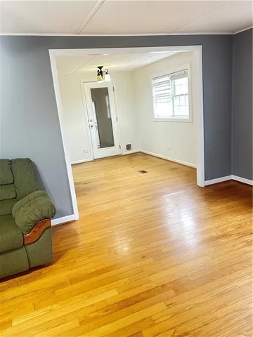 a view of a livingroom with wooden floor and a window