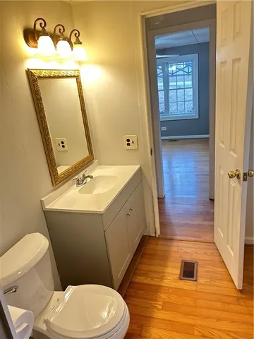 a bathroom with a sink mirror vanity and toilet