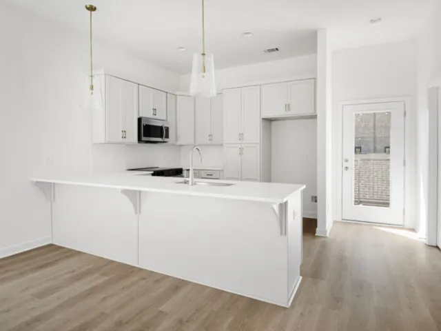 a kitchen with kitchen island a stove a sink and a refrigerator