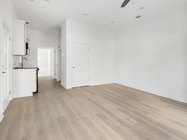 a view of a kitchen with white cabinets and a sink