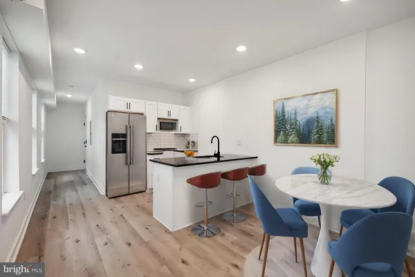 a kitchen with stainless steel appliances kitchen island granite countertop a sink and a refrigerator