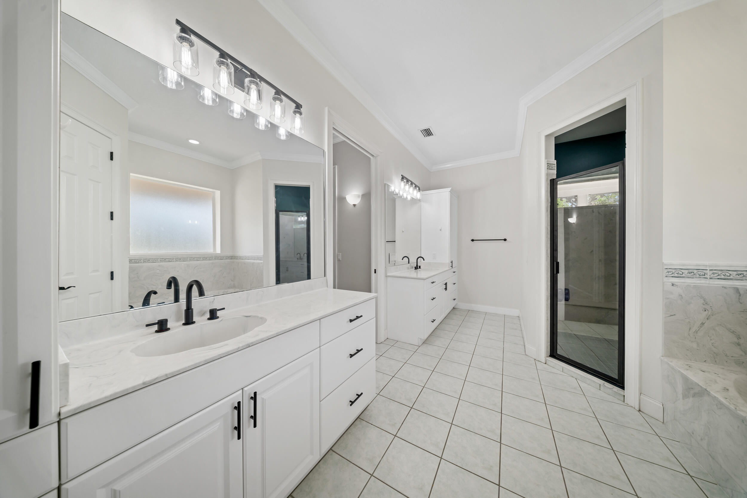 8686 Andrews Avenue Fort Pierce, FL 34945 - Photo 28 of 76 a bathroom with a double vanity sink a mirror and a shower