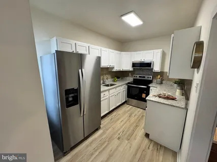 a kitchen with stainless steel appliances a refrigerator a stove a sink a washer dryer and a refrigerator