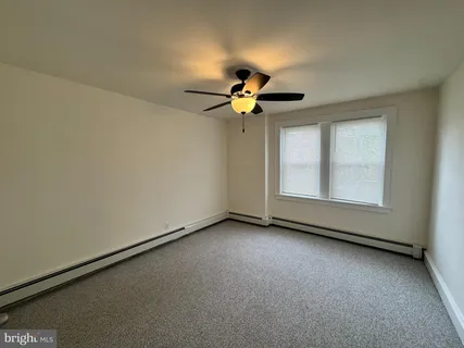 a view of room with ceiling fan and window