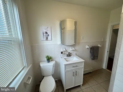 a bathroom with a toilet sink and mirror