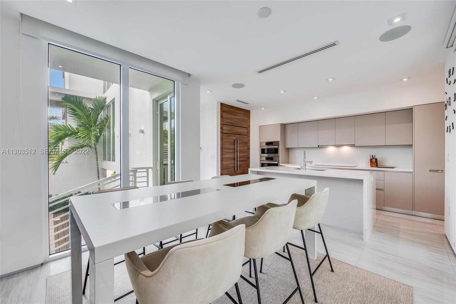 330 Fernwood Road, Unit 1 Key Biscayne, FL 33149 - Photo 11 of 29 a kitchen with a table chairs refrigerator and cabinets