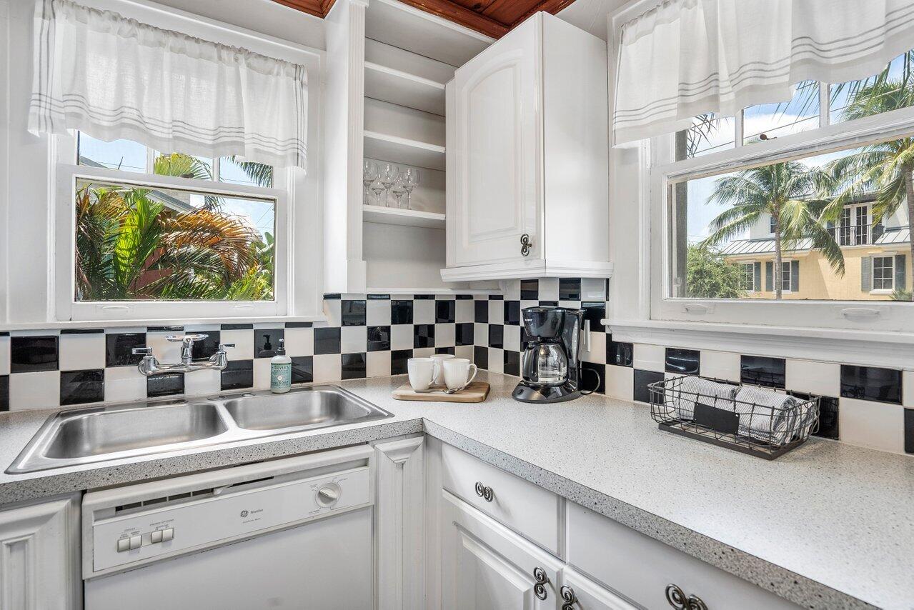 102 Southeast 7th Avenue, Unit VILLA 2 Delray Beach, FL 33483 - Photo 13 of 28 a kitchen with a sink a stove and a window with potted plants