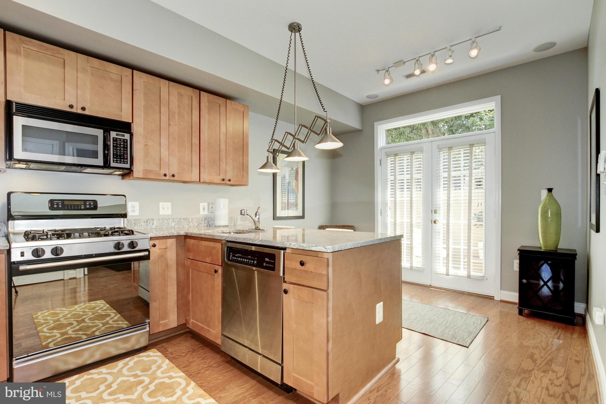 27 Logan Circle Northwest, Unit 1 Washington, DC 20005 - Photo 11 of 30 a kitchen with stainless steel appliances granite countertop a stove a sink and a microwave