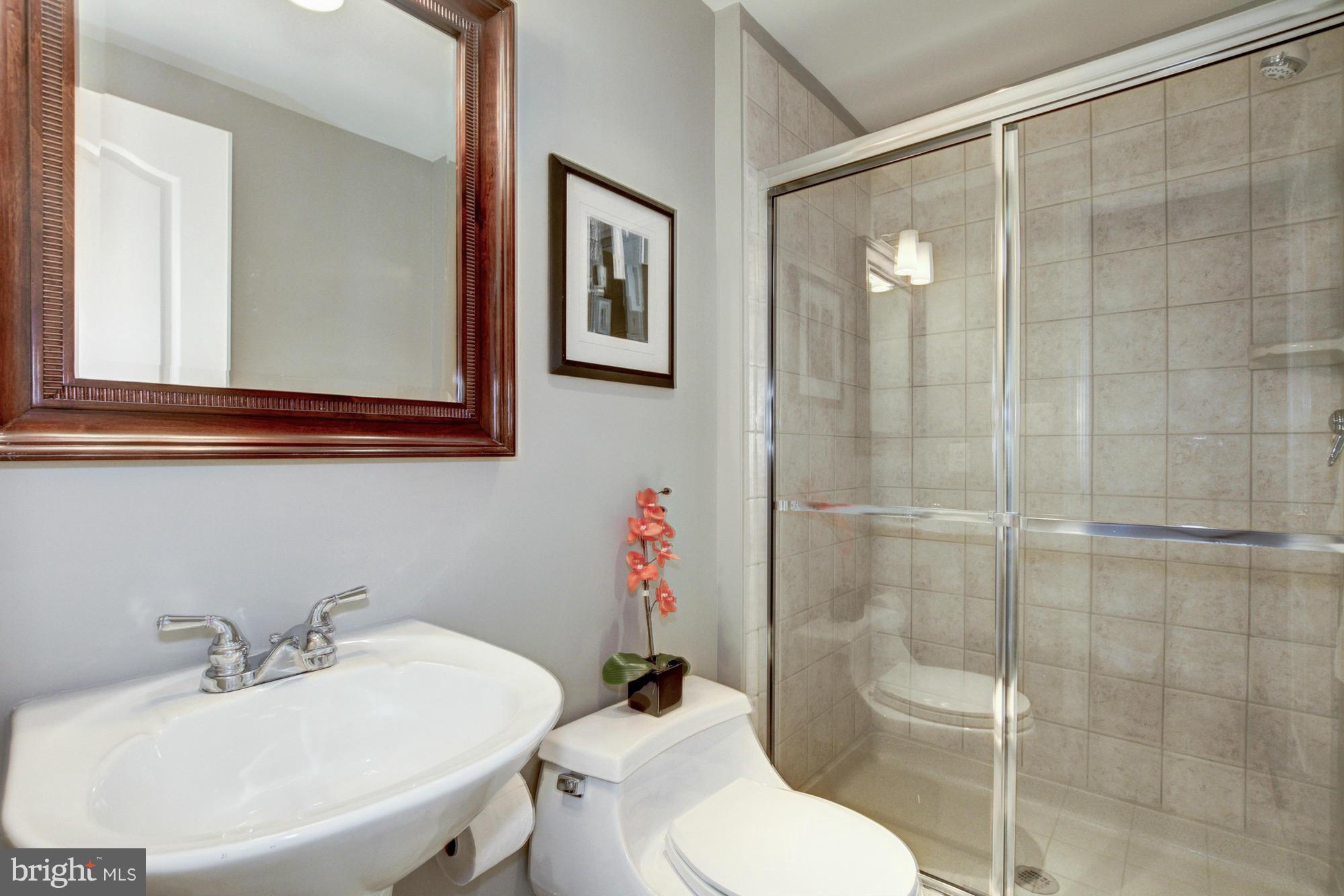 27 Logan Circle Northwest, Unit 1 Washington, DC 20005 - Photo 24 of 30 a bathroom with a sink mirror toilet and shower