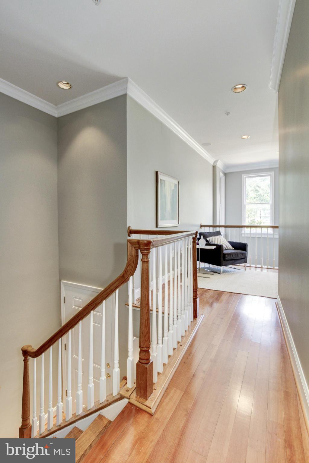 27 Logan Circle Northwest, Unit 1 Washington, DC 20005 - Photo 25 of 30 a view of a hallway to a livingroom with wooden floor and stairs