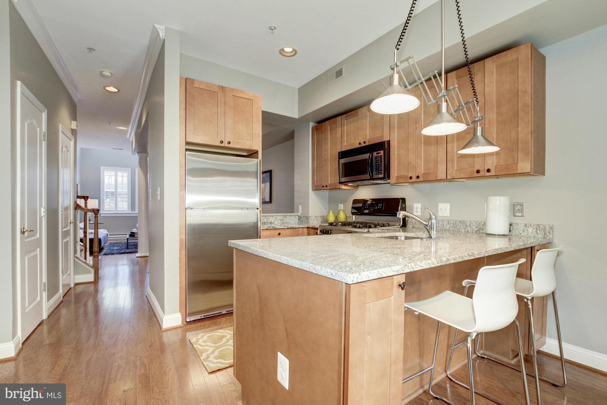 27 Logan Circle Northwest, Unit 1 Washington, DC 20005 - Photo 10 of 30 a kitchen with a sink a microwave a stove and refrigerator