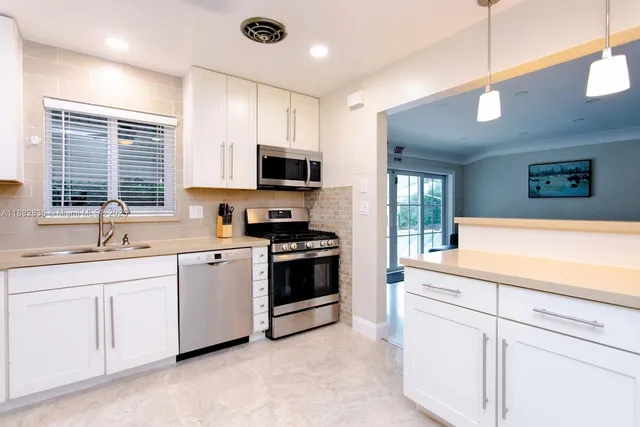 a kitchen with stainless steel appliances granite countertop a sink and stove top oven
