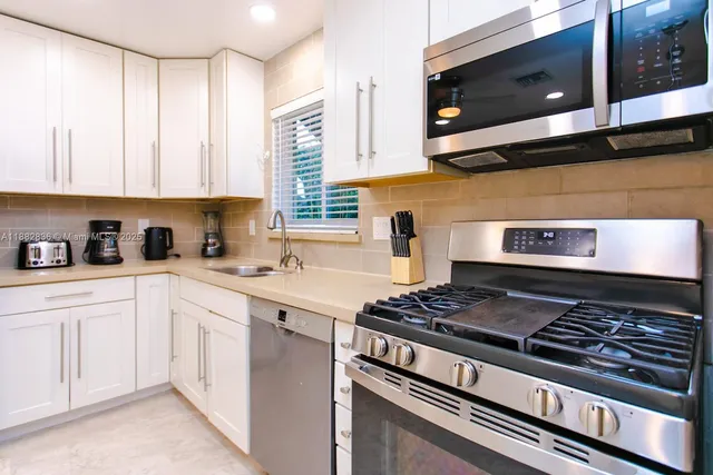 a kitchen with stainless steel appliances granite countertop a stove a microwave and cabinets