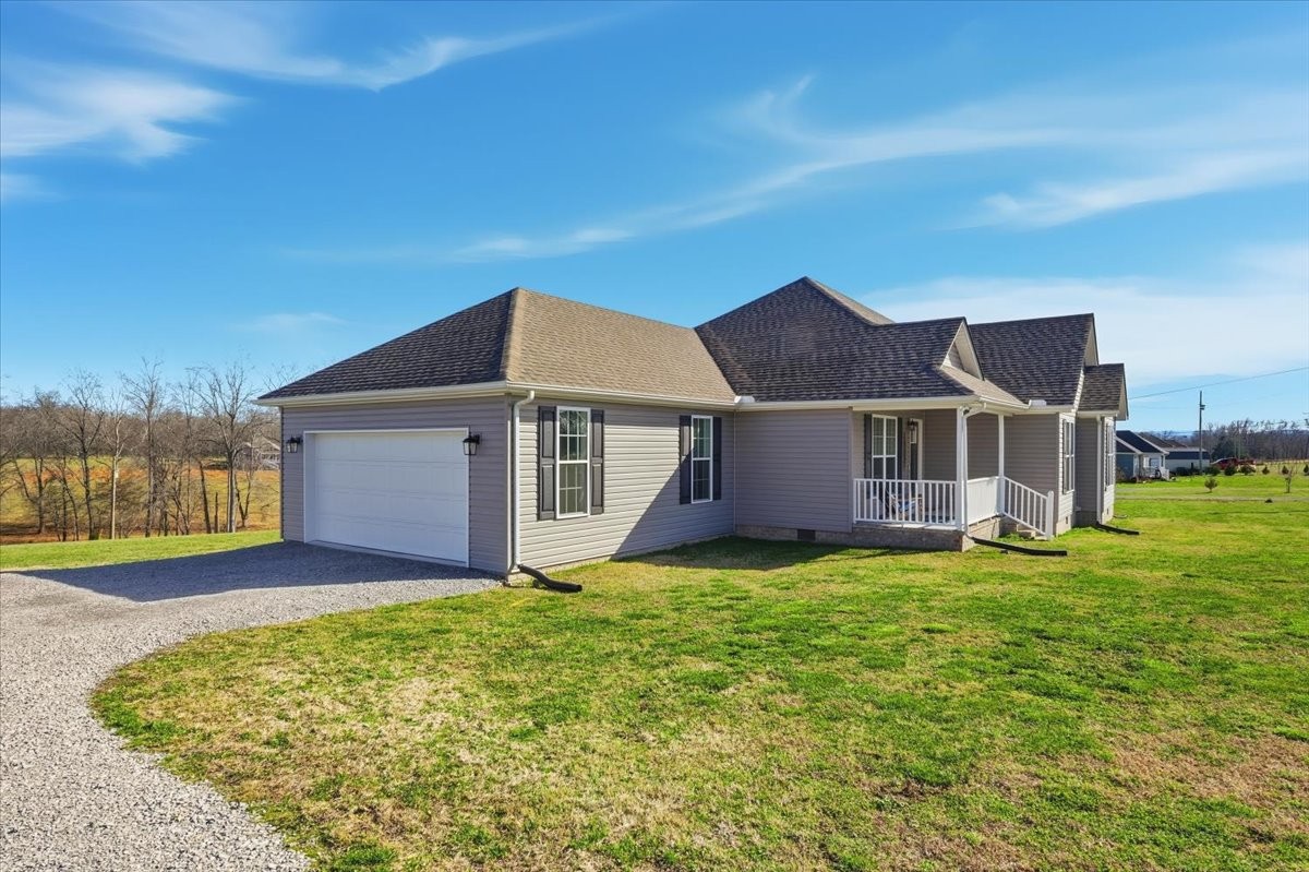 186 L Mitchell Road Flintville, TN 37335 - Photo 4 of 40 a house that is sitting in the grass with large trees