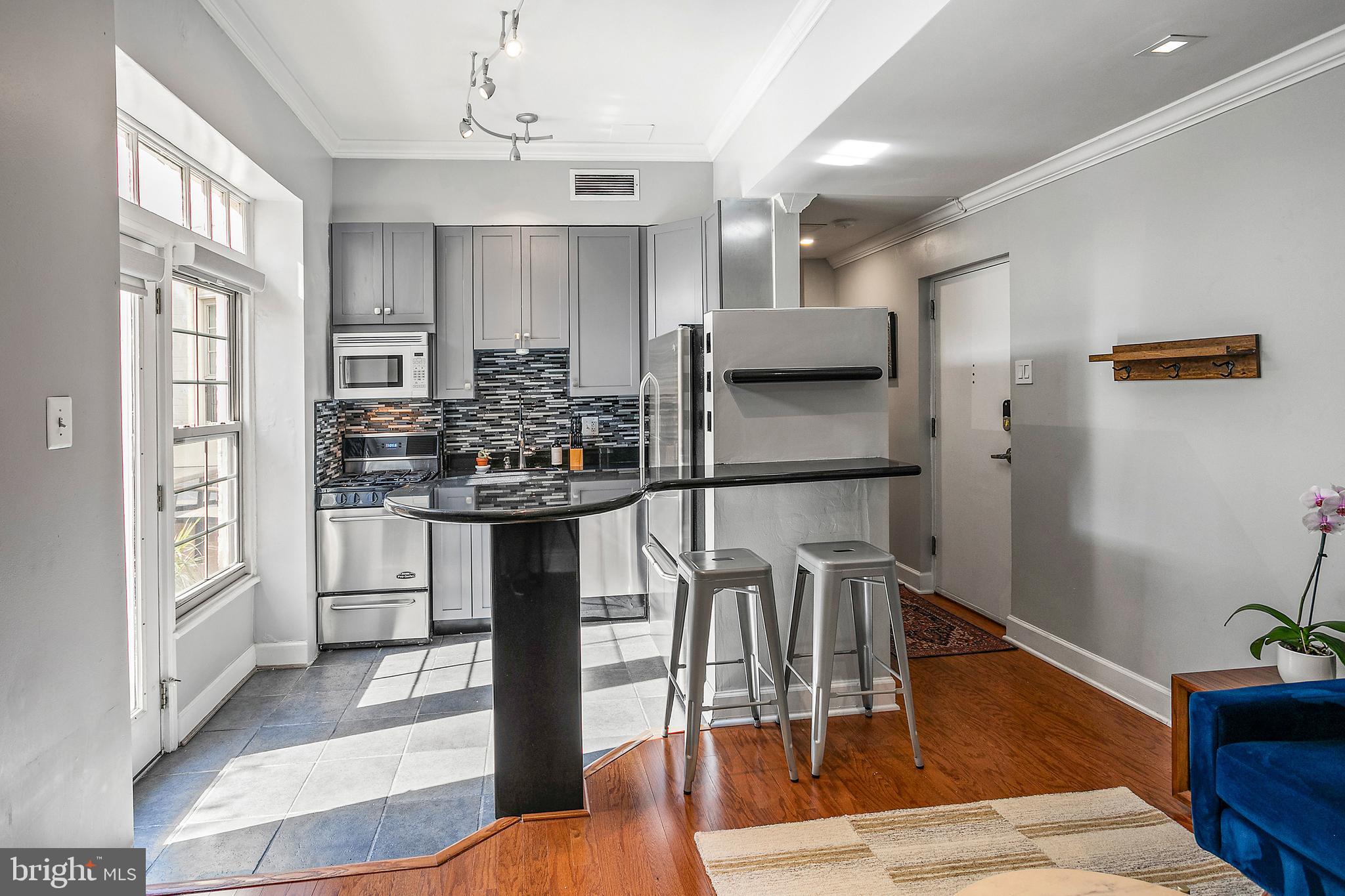 101 North Carolina Avenue Southeast, Unit 110 Washington, DC 20003 - Photo 6 of 27 a kitchen with stainless steel appliances kitchen island granite countertop a refrigerator and microwave