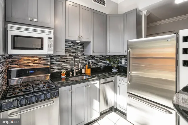 a kitchen with stainless steel appliances a stove and a microwave