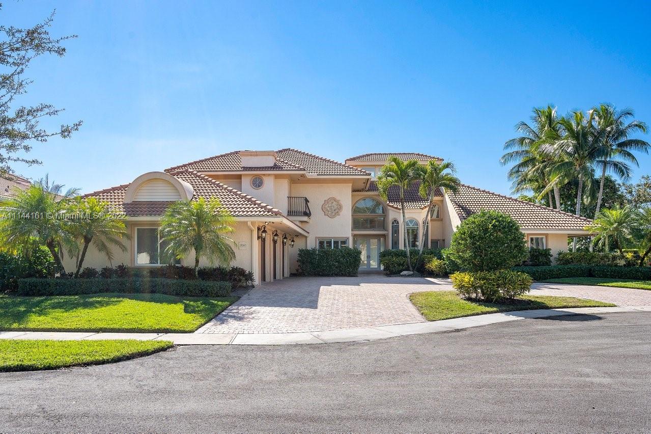 3060 Hampton Place Boca Raton, FL 33434 - Photo 1 of 60 a view of a white house with a swimming pool and a yard with lawn chairs under an umbrella