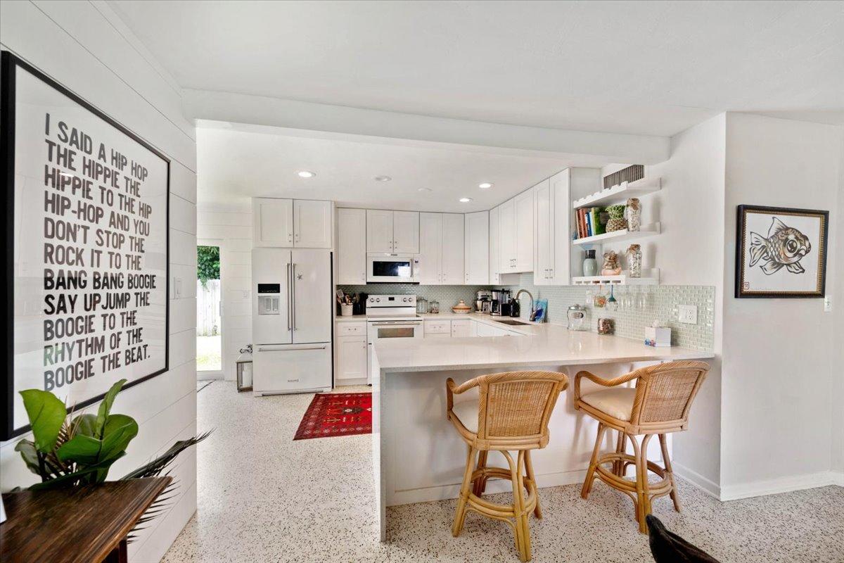 200 East 28th Street Riviera Beach, FL 33404 - Photo 6 of 22 a living room with stainless steel appliances kitchen island granite countertop furniture and a rug