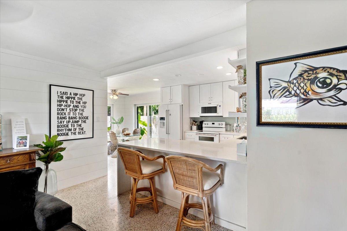 200 East 28th Street Riviera Beach, FL 33404 - Photo 7 of 22 a kitchen with stainless steel appliances granite countertop a refrigerator and a stove top oven