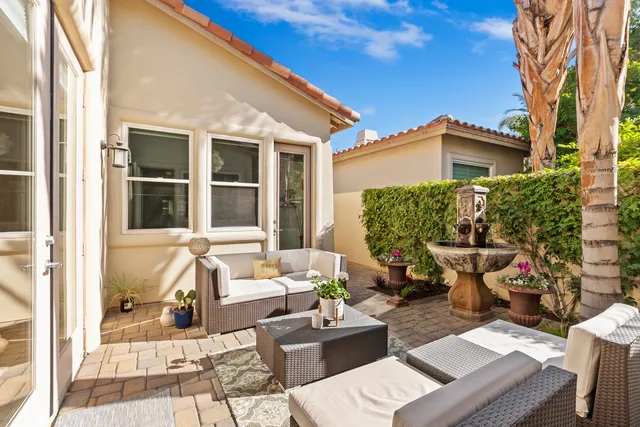 a view of a patio with couches table and chairs and potted plants