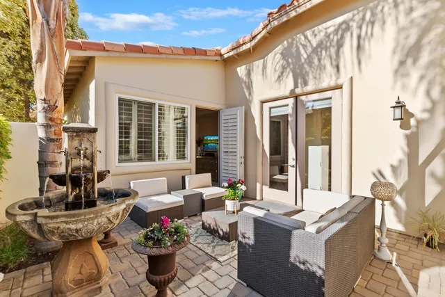 a view of a patio with couches table and chairs and potted plants
