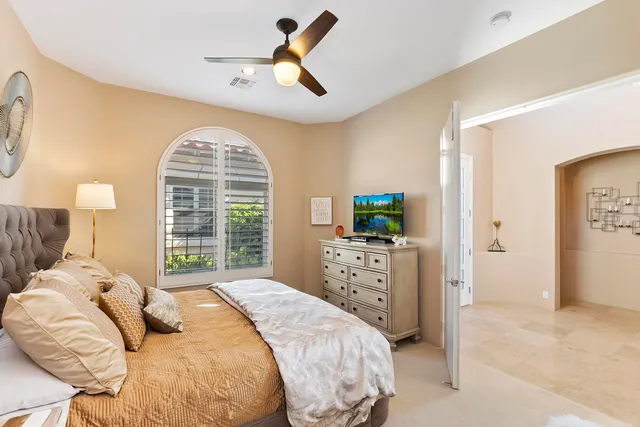 a bedroom with a bed a window and a chandelier