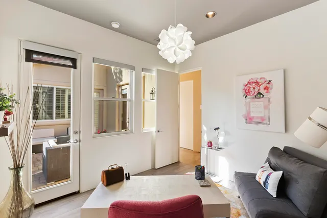 a living room with furniture flowerpot and a chandelier