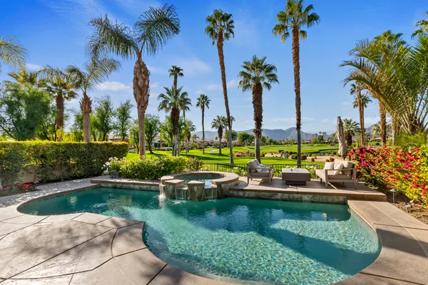 a view of swimming pool with a garden and outdoor seating