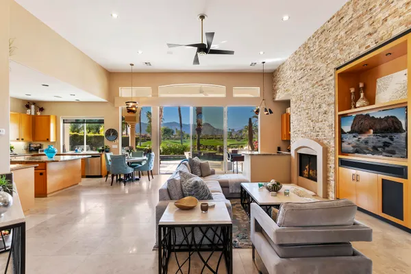 a living room with fireplace furniture and a large window