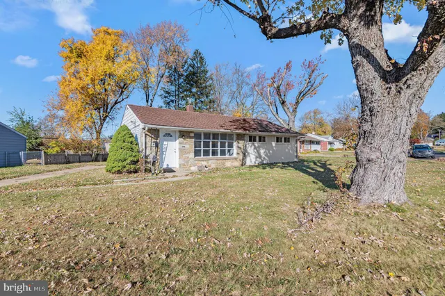 a yellow house with trees in front of it