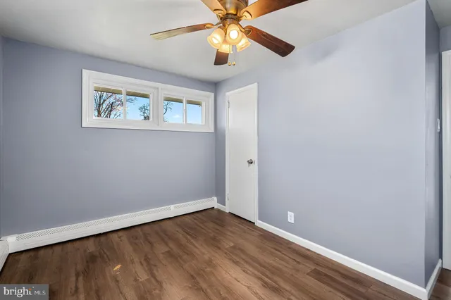 an empty room with a window and a ceiling fan