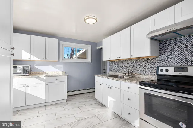 a kitchen with cabinets appliances and a sink