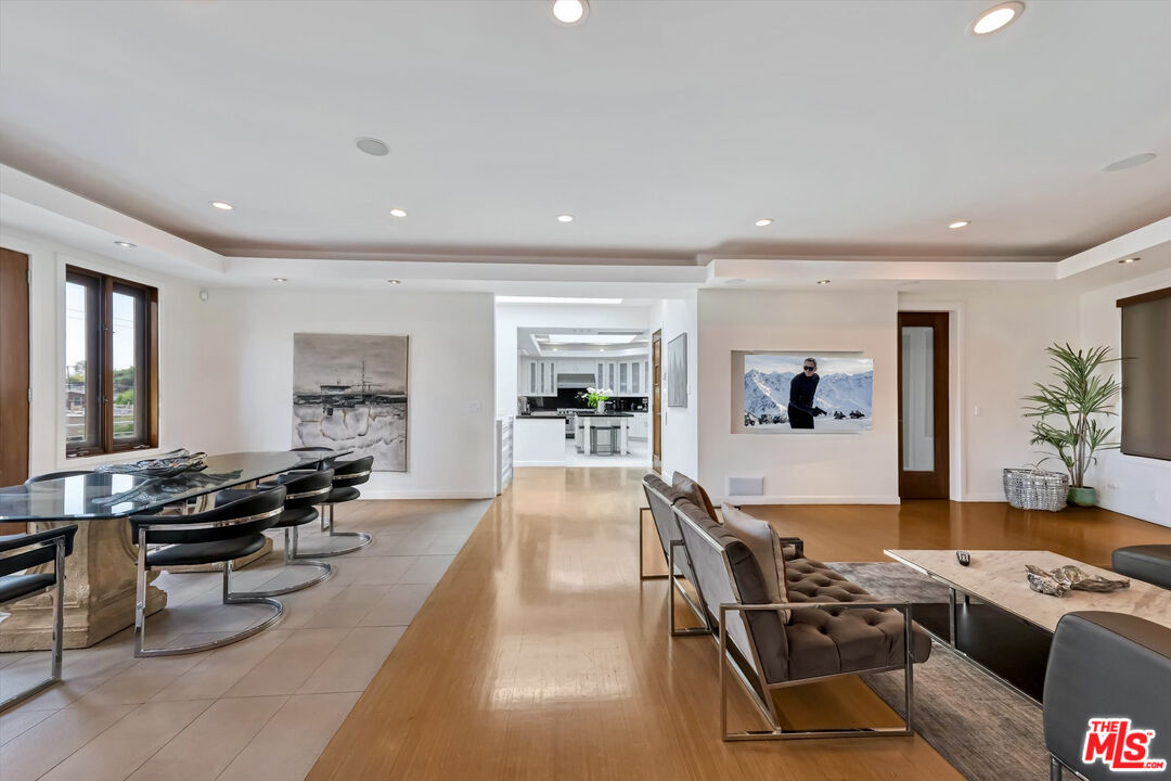 a living room with furniture a flat screen tv and a large window
