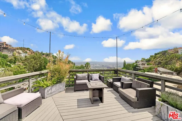 a view of roof deck with seating space and trees