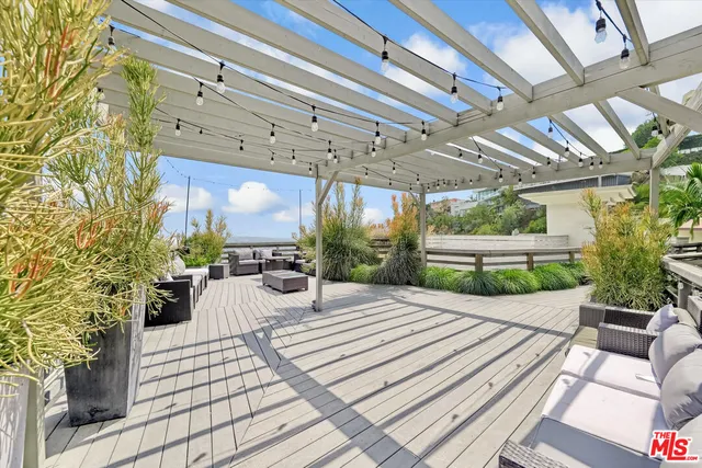 a view of a patio with table and chairs potted plants with wooden floor and fence
