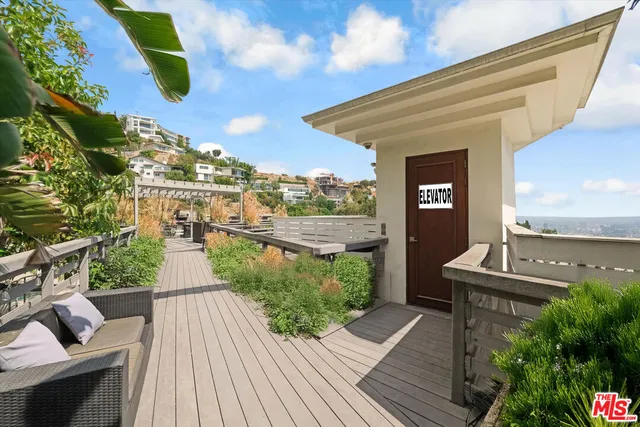 a view of a balcony with wooden floor and outdoor seating