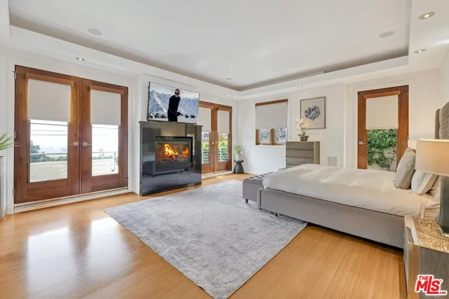 a spacious bedroom with a large bed and a flat tv screen