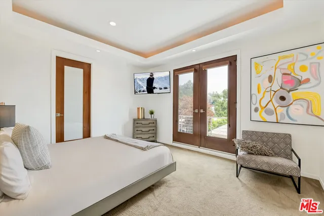 a bedroom with a large bed and a painting on the wall