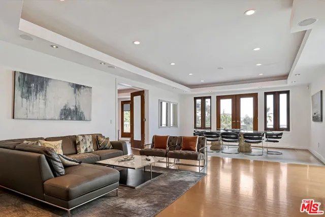 a living room with furniture wooden floor and a large window