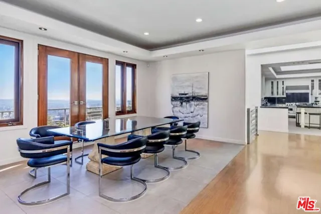 a room with lots of tables a large window and chairs