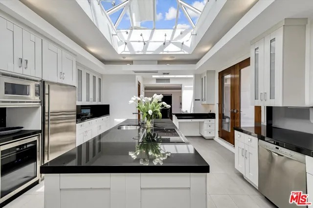 a kitchen with stainless steel appliances granite countertop a sink a stove and a refrigerator