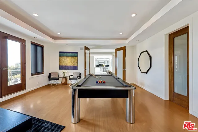 a living room with furniture a pool table and a large window