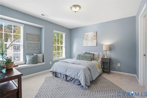 a bedroom with a large bed couch and a window