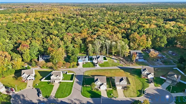 an aerial view of a house with a yard and lake view