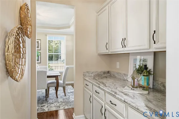 a kitchen with granite countertop a sink and a white wooden cabinets