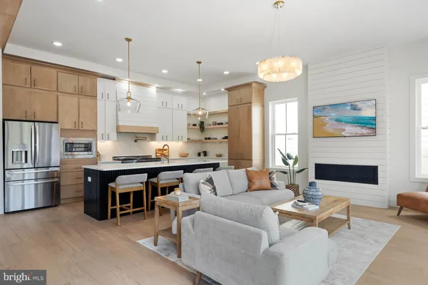 a living room with stainless steel appliances kitchen island granite countertop furniture and a large window